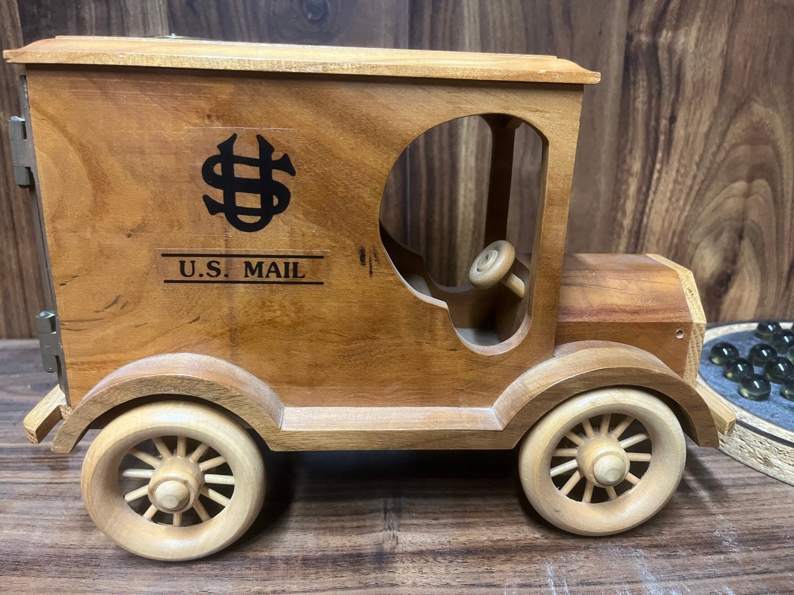 Handmade wooden U.S. Mail truck bank with coin slot, working combination lock, and metal post office box door.